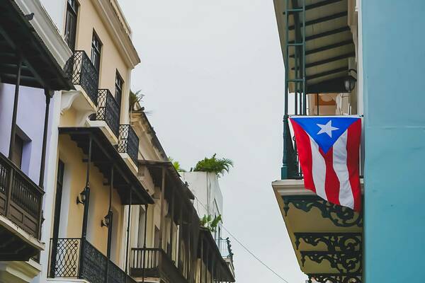 Puerto Rican flag hanging from top floor apartment balcony