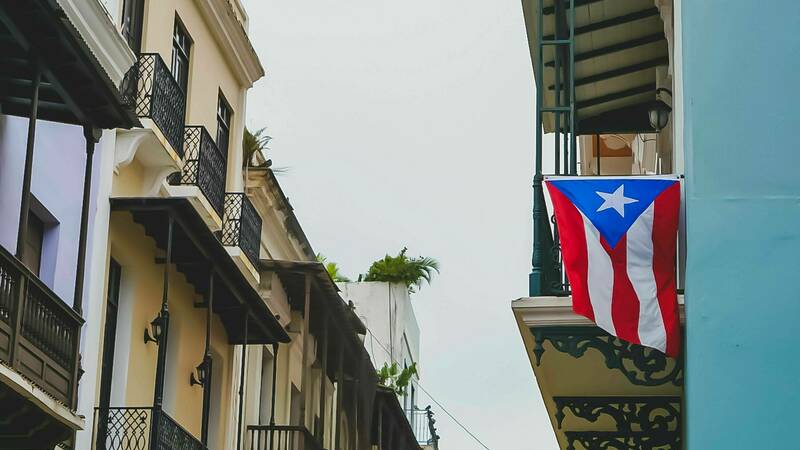 Puerto Rican flag hanging from top floor apartment balcony