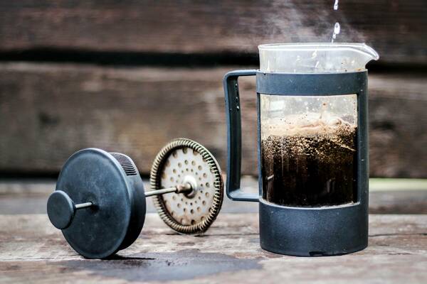French press with used coffee grinds in it