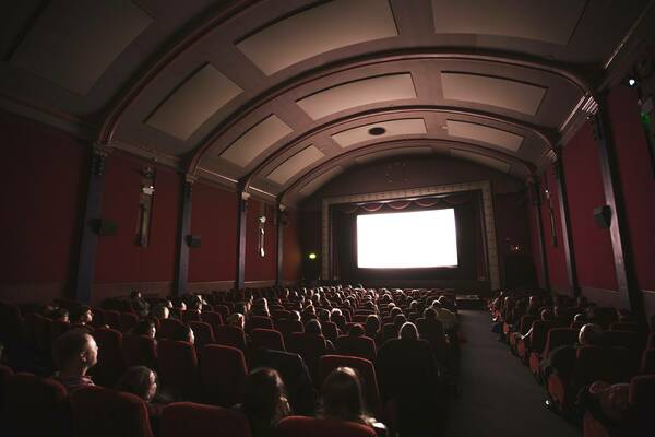 Darkened movie theater with audience watching the screening of a film