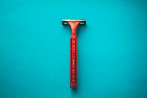 Image of a razor against a teal backdrop