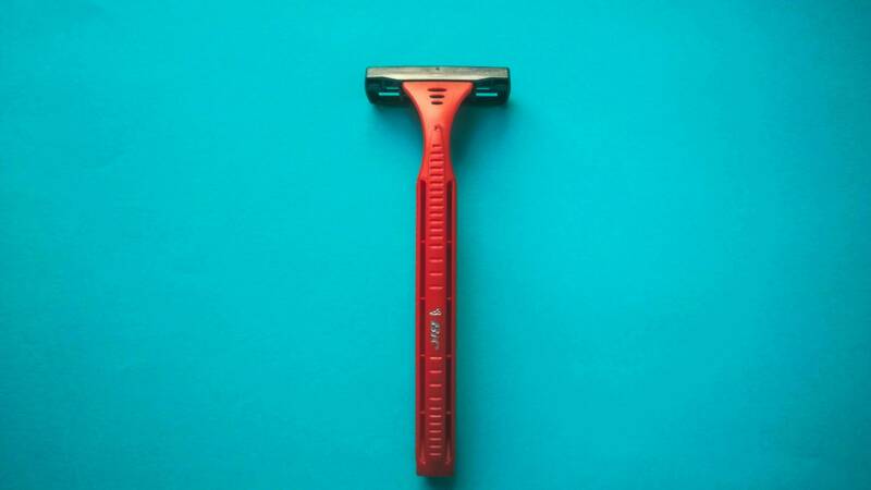 Image of a razor against a teal backdrop