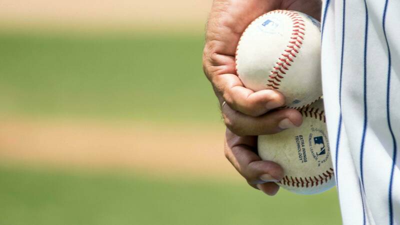 Image of baseball pitcher holding two baseballs