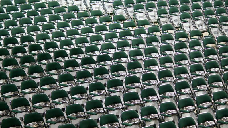 Many rows of empty green chairs, from above.