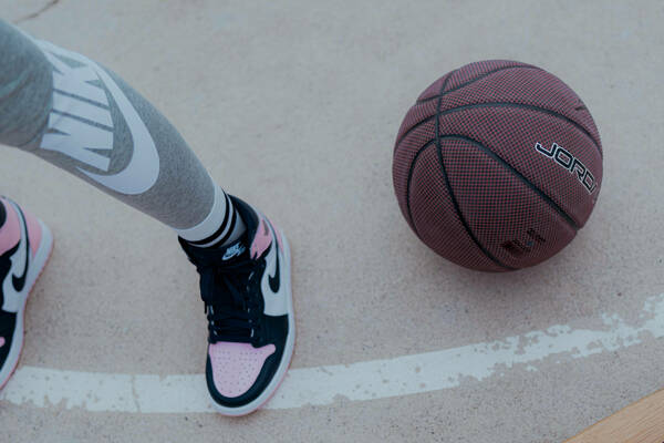 Image of basketball player with pink shoes next to a basketball