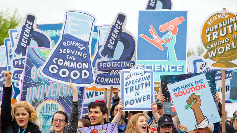 Protest signs praising the work of science