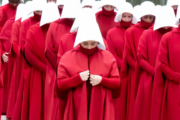 A photo of women in rows dressed in infamous red costuming from The Handmaid's Tale television series