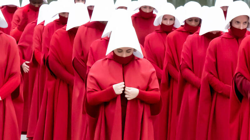 A photo of women in rows dressed in infamous red costuming from The Handmaid&#39;s Tale television series
