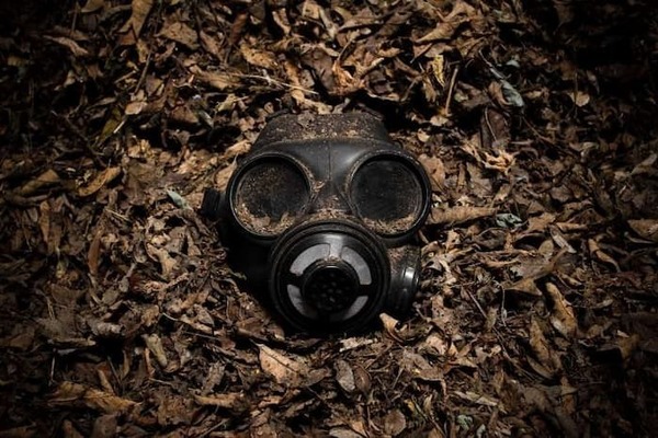 A gas mask on top of a pile of leaves