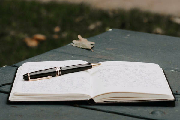 Image of notebook, pen, and leaf