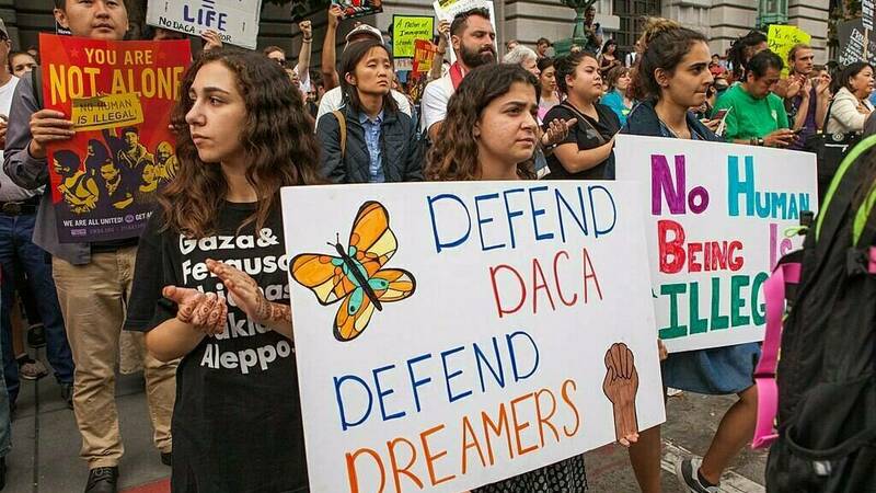 People holding signs in support of DACA and Dreamers at a rally in San Francisco