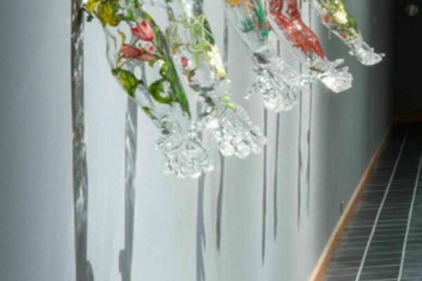 A sculpture of glass arms with flowers inside