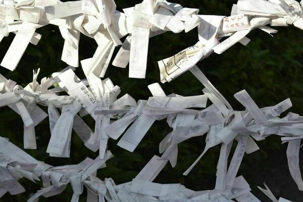 Paper fortunes in Japanese tied to a fence