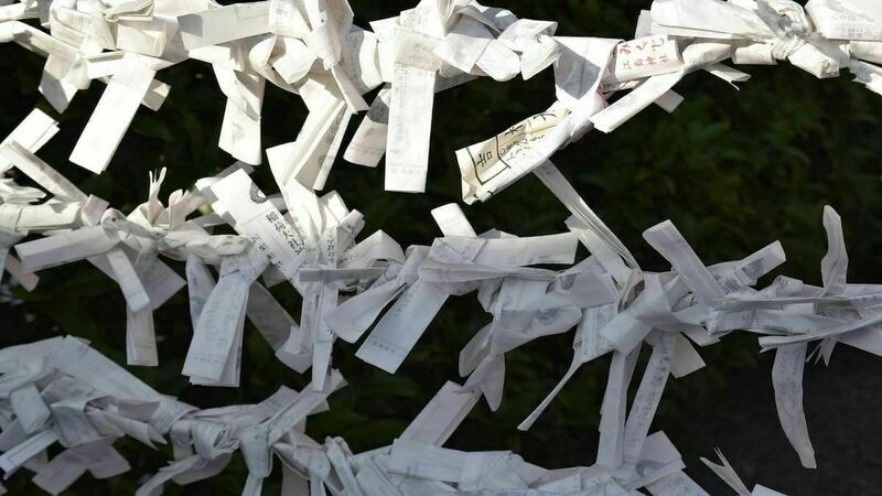 Paper fortunes in Japanese tied to a fence